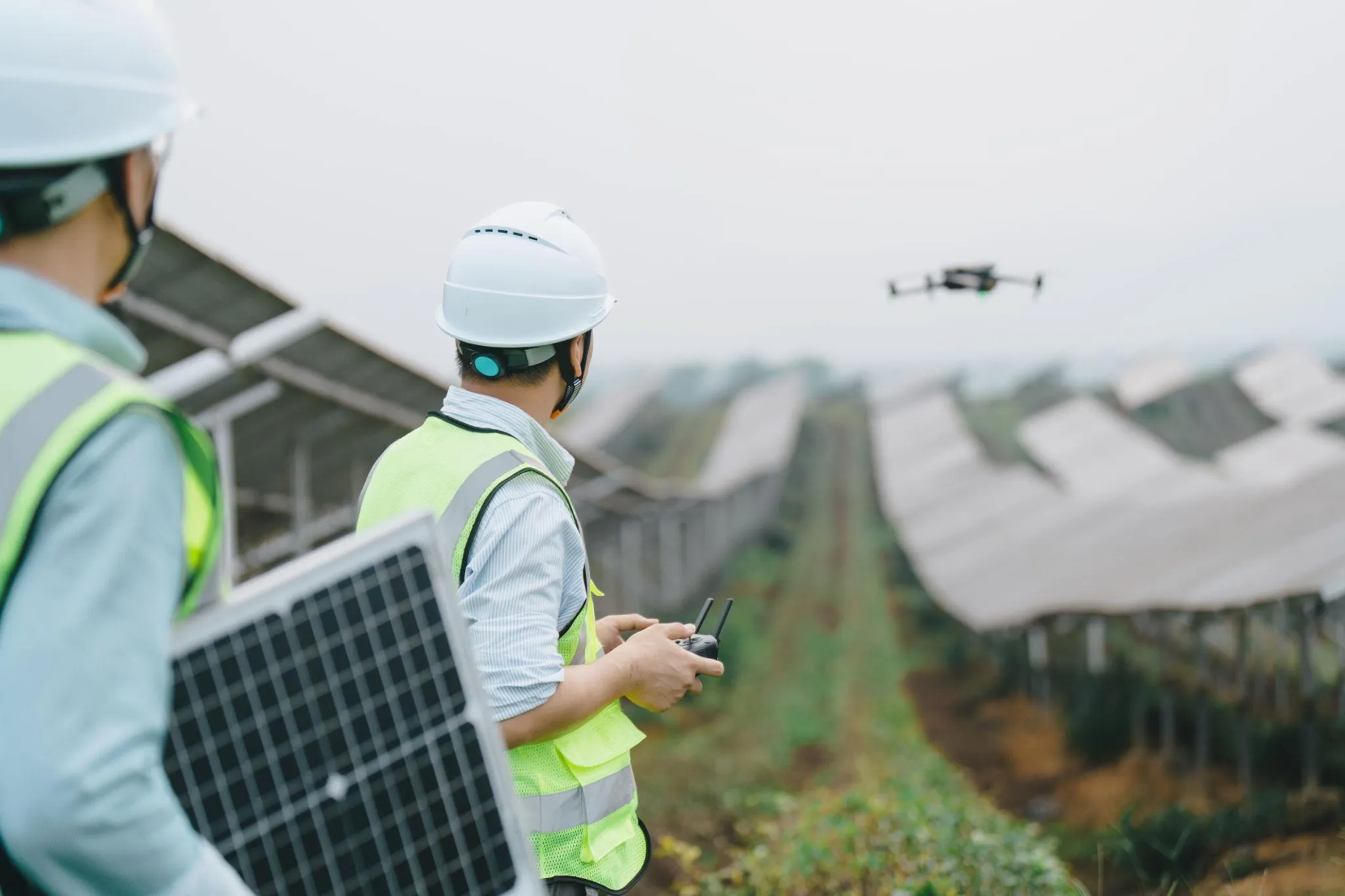 Technician inspecting solar panels with thermal camera