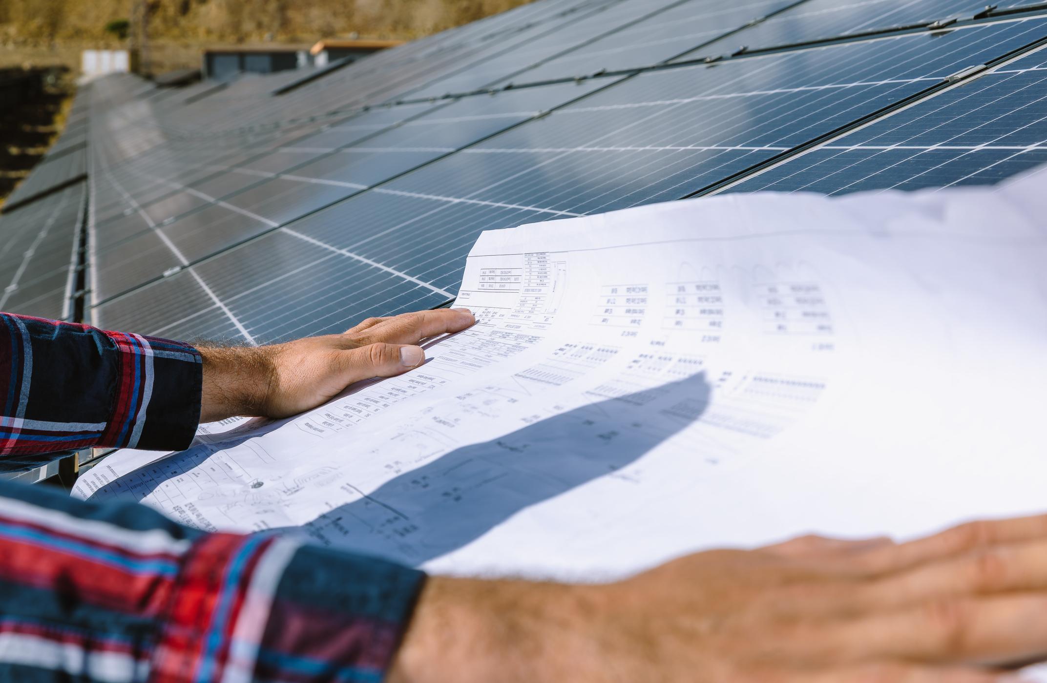 Engineer reviewing solar plans on site