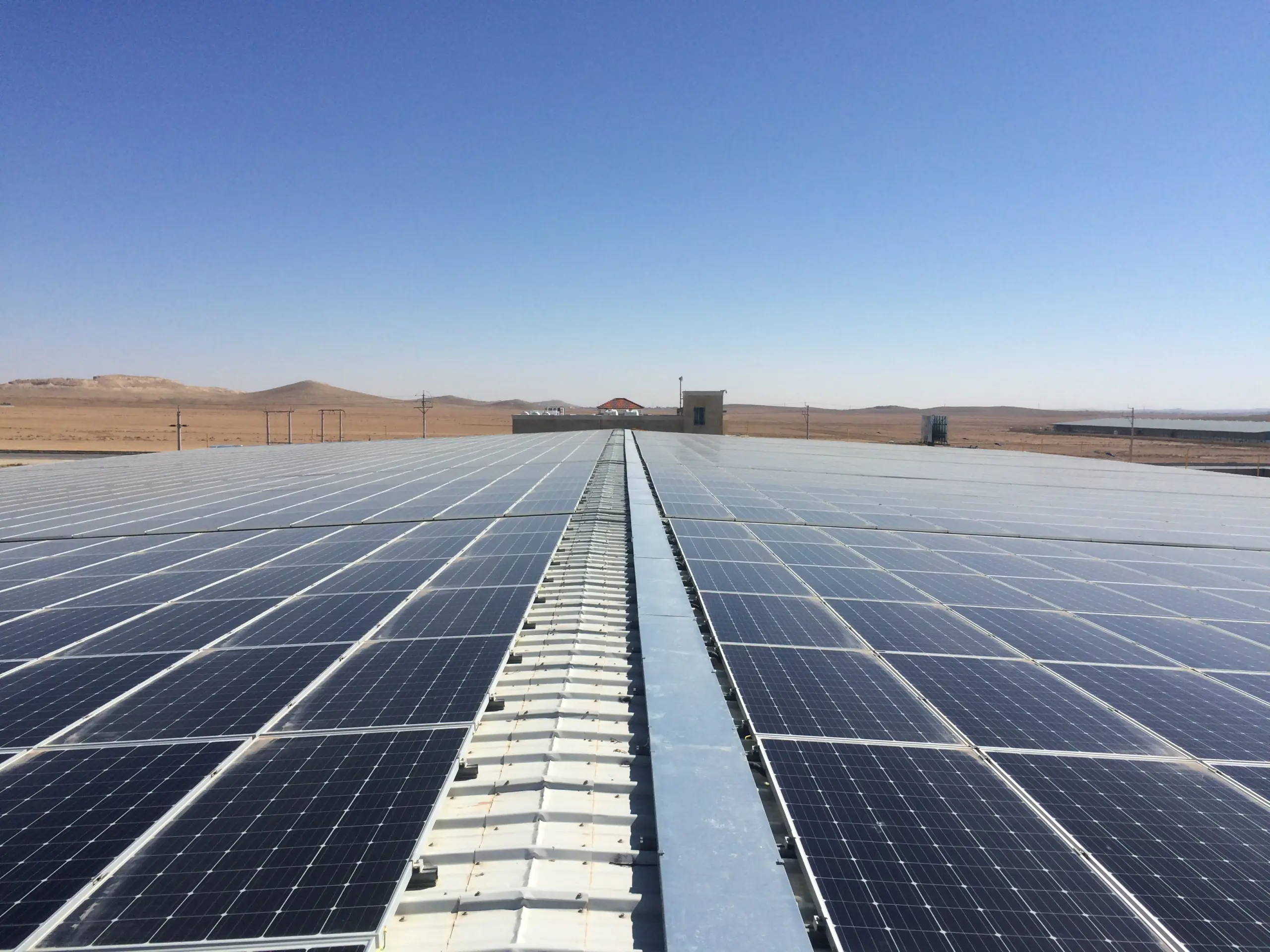 Close view of rooftop PV module rows at the Al Emlaq solar project