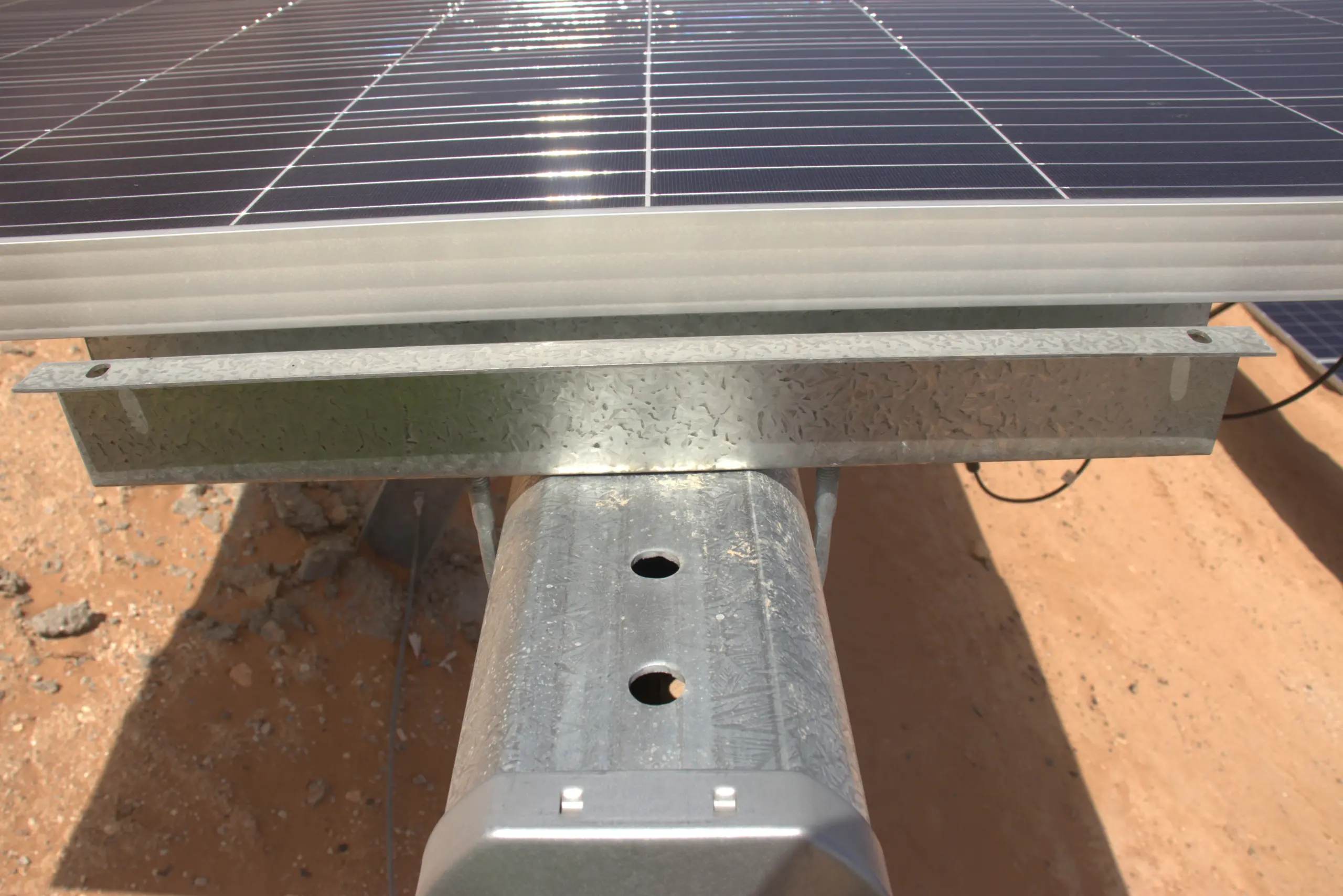 Heavy-duty galvanized steel support assembly beneath a photovoltaic module