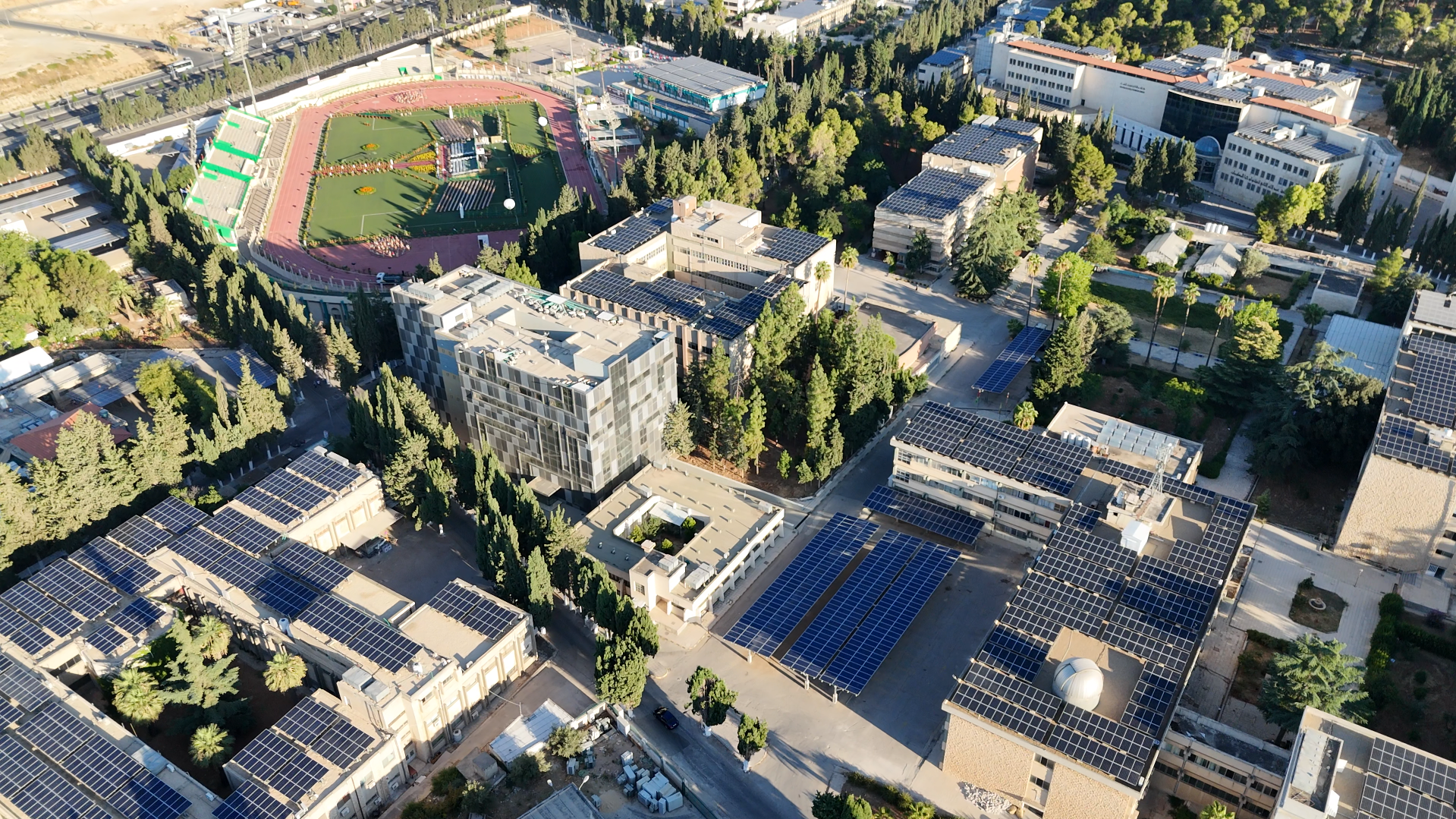 Aerial view of University of Jordan solar PV park across campus buildings and carparks